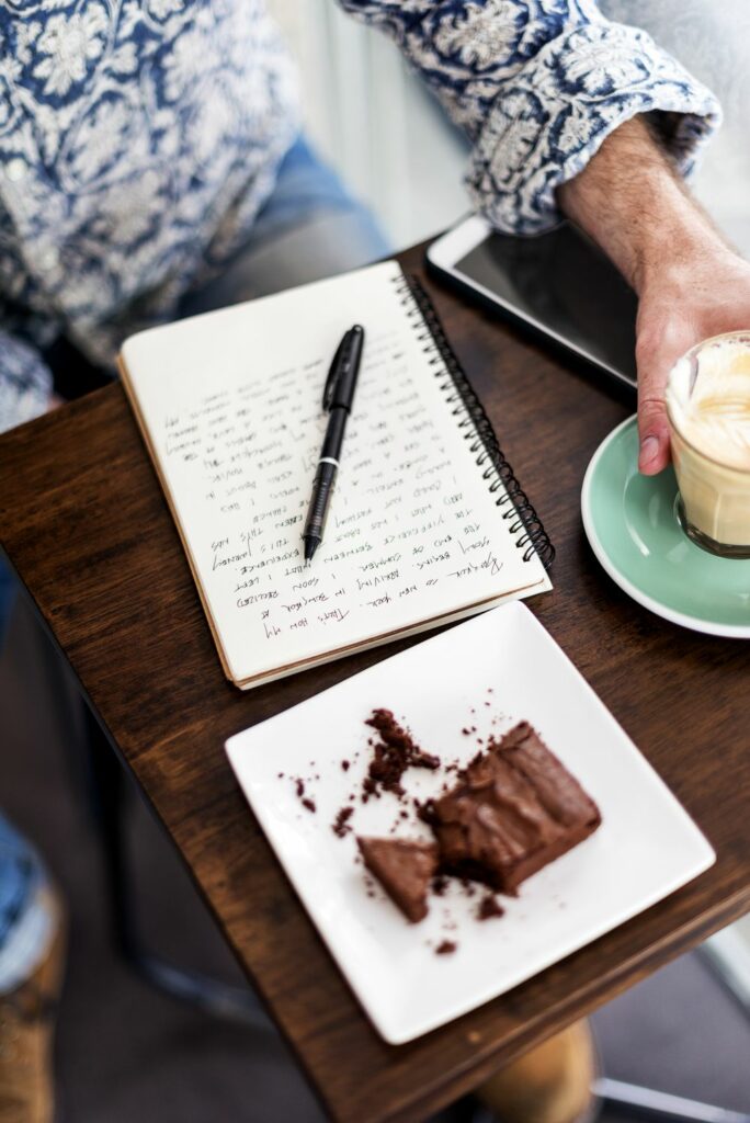 Closeup of journey notebook on wooden table at cafe