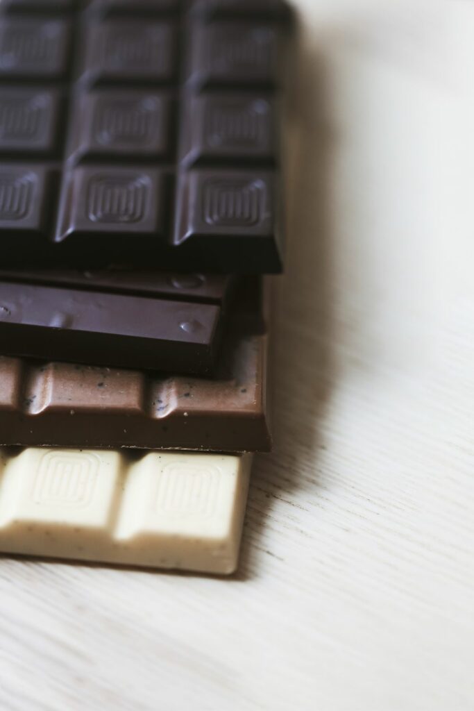 various-chocolate-bar-stack-wooden-textured-backdrop